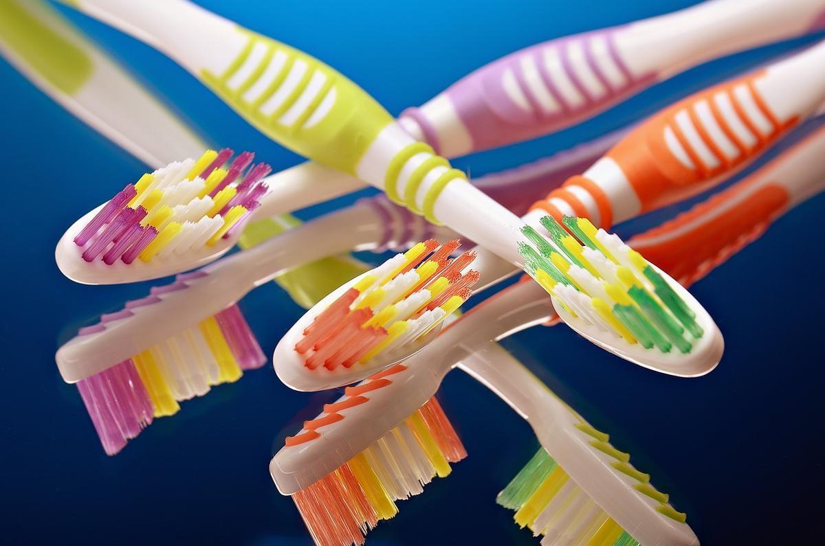 Brosses à dents colorées disposées en diagonale sur fond bleu Brosses à dents colorées disposées en diagonale sur fond bleu
