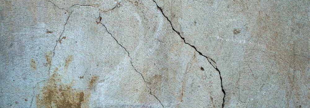 Mur de béton avec fissures et taches d’humidité