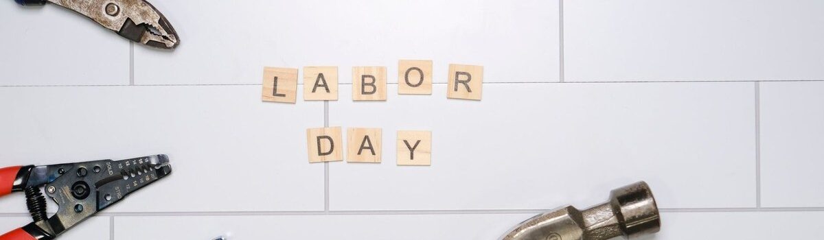 Outils de bricolage sur carrelage avec les mots "LABOR DAY" en caractères en bois
