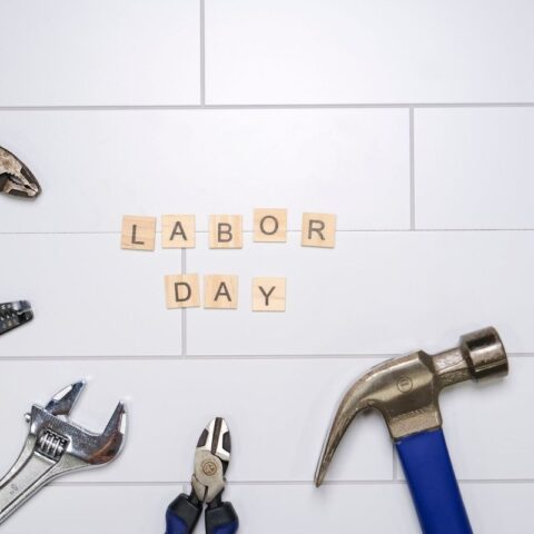 Outils de bricolage sur carrelage avec les mots "LABOR DAY" en caractères en bois
