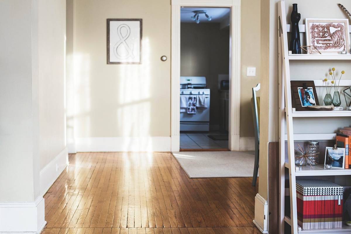 Intérieur d'une maison avec parquet, tableau, porte ouverte et étagère